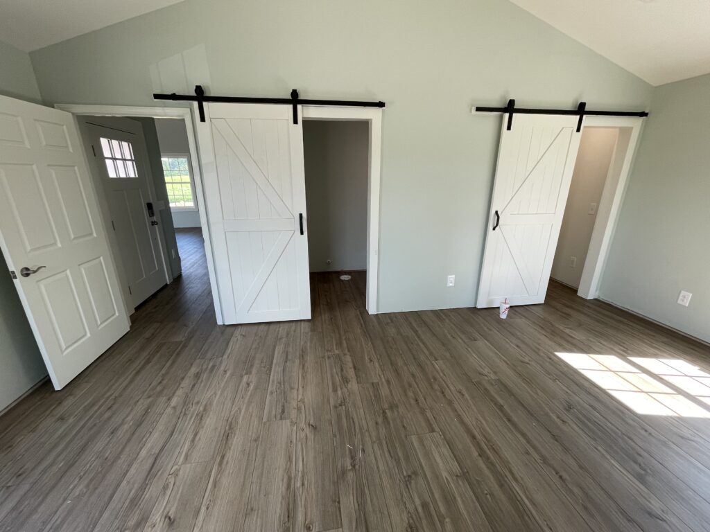 A completed 314-INSTALL LVP floor in a bright room with barn doors