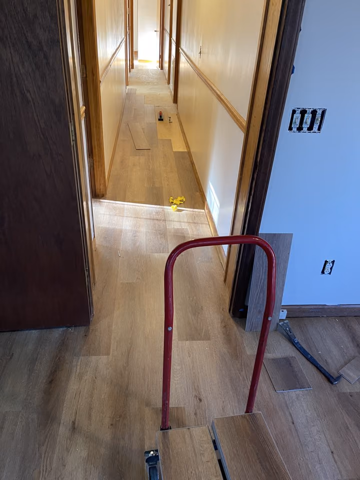 Hallway and adjoining room during click-lock LVP installation.
